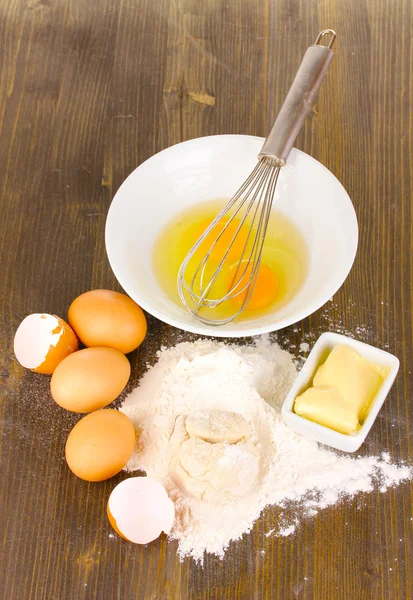 Huevos, harina y mantequilla de cerca en la mesa de madera —  Fotos de Stock