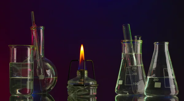 Spiritlamp and test-tubes on blue-red background — Stock Photo, Image