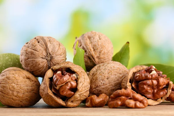 Walnuts with green leaves, on green background — Stock Photo, Image