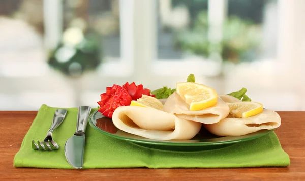 Calamares hervidos con verduras en el plato en la mesa de madera de cerca —  Fotos de Stock