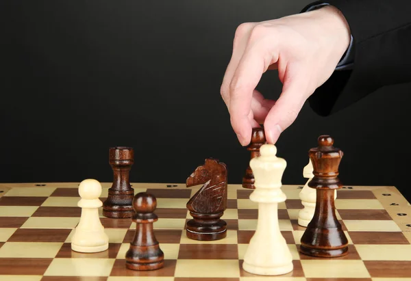 Geschäftsmann spielt Schach isoliert auf Schwarz — Stockfoto