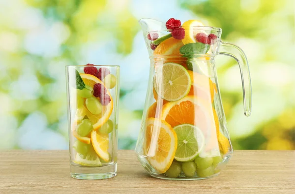 Sklenice a sklo s citrusových plodů a maliny, na zeleném pozadí — Stock fotografie