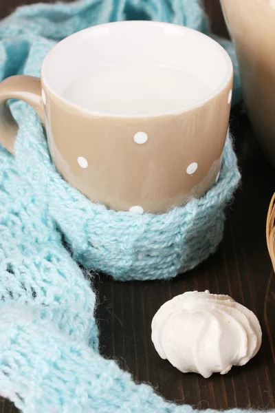 Džbán a hrnek mléka s pusinky na dřevěný stůl detail — Stock fotografie