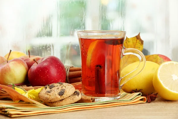 Beker van hete thee en herfst bladeren, op houten tafel — Stockfoto