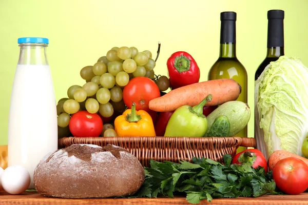 Composición con verduras en canasta de mimbre sobre fondo verde — Foto de Stock