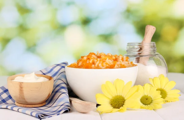 Useful pumpkin porridge in white plate on wooden table on natural background — Stock Photo, Image