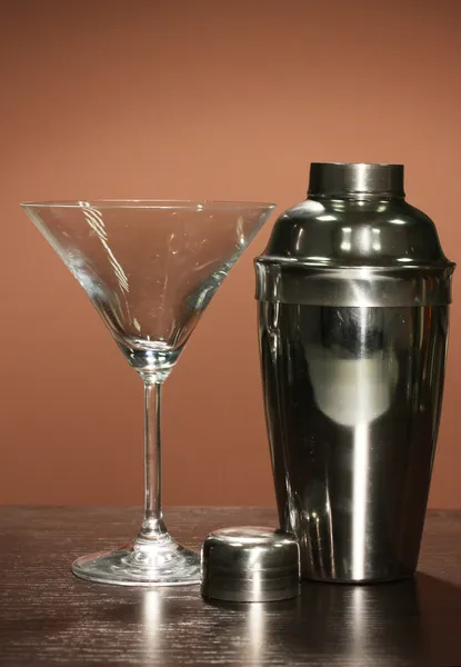 Cocktail shaker and cocktail glass on color background — Stock Photo, Image