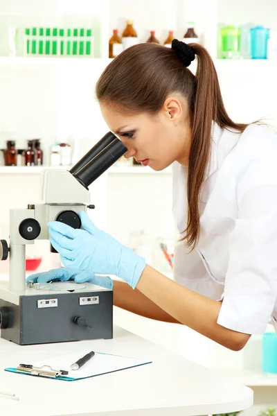 Young scientist looking into microscope in laboratory — Stock Photo, Image