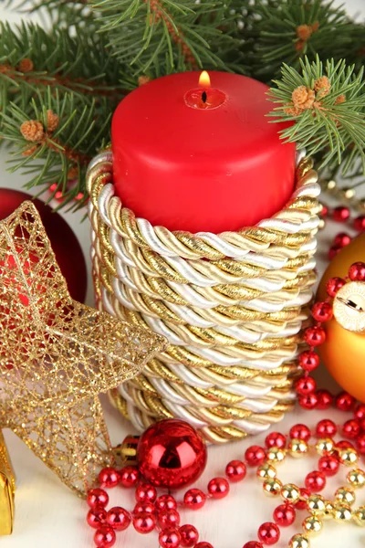 Vela roja con decoración navideña sobre fondo claro —  Fotos de Stock