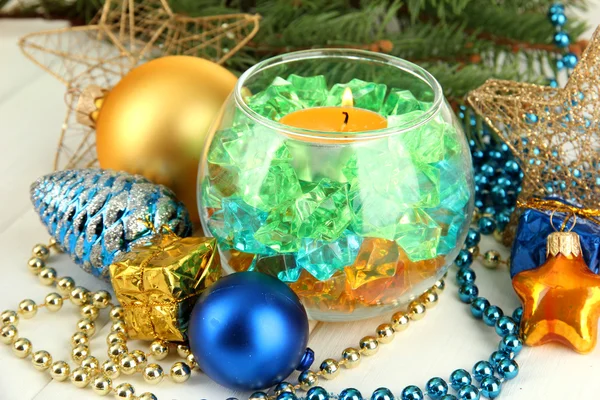 Gelbe Kerze mit Weihnachtsdekoration auf hellem Hintergrund — Stockfoto