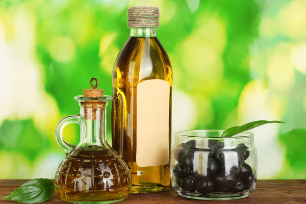 Bouteille d'huile d'olive et petite carafe sur fond vert — Photo