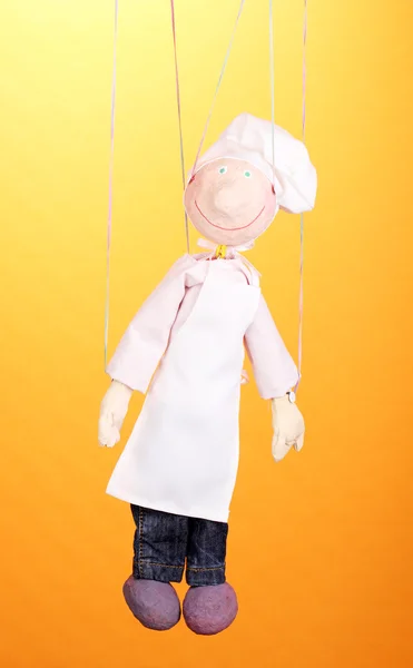 Marionnette en bois comme cuisinier sur fond orange — Photo