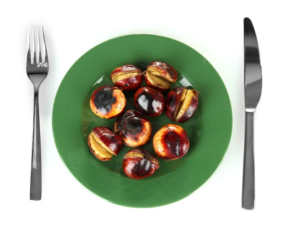 Roasted chestnuts in the green plate with fork and knife isolated on white — Stock Photo, Image