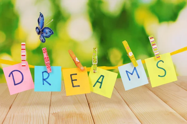 The word Dreams on wooden table on natural background — Stock Photo, Image