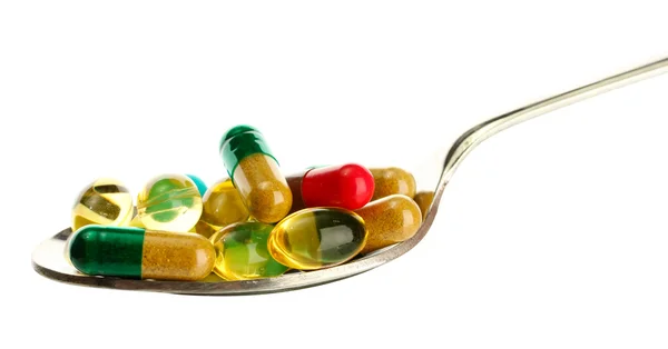 Spoon with colorful capsules and pills, isolated on white — Stock Photo, Image