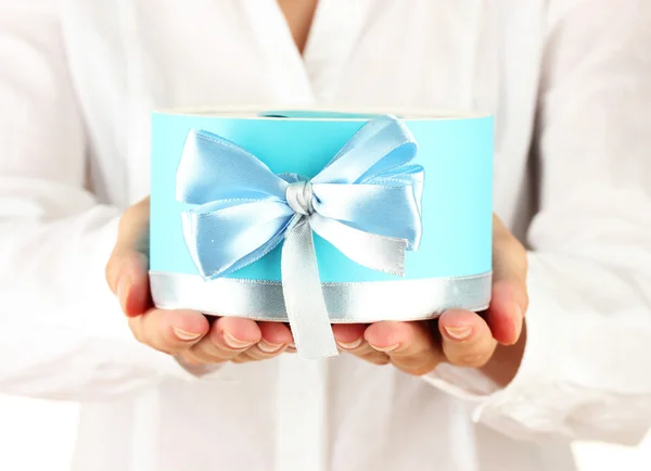 Vrouw houdt een doos met een gift op witte achtergrond close-up — Stockfoto