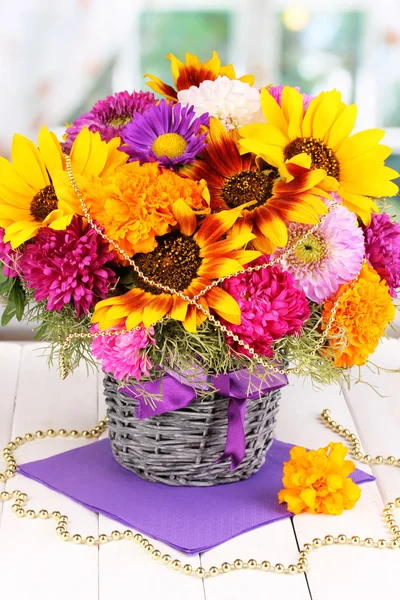 Hermoso ramo de flores brillantes en la mesa de madera en el fondo de la ventana — Foto de Stock