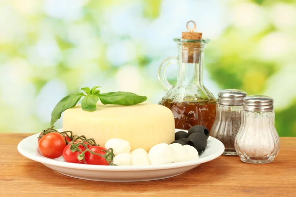 Keju mozzarella dengan sayuran di piring di atas meja kayu close-up — Stok Foto
