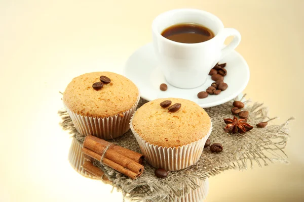 Gustose torte di muffin con spezie su tela e tazza di caffè, su sfondo beige — Foto Stock