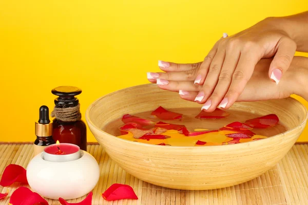 Tratamientos de spa para manos femeninas, sobre fondo amarillo — Foto de Stock