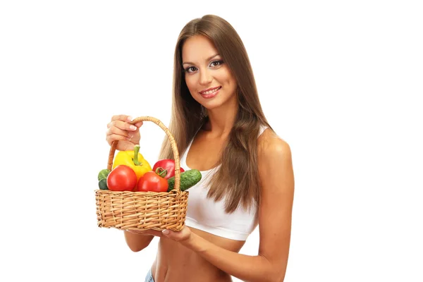 Красивая молодая женщина с овощами в корзине, изолированные на белом — стоковое фото