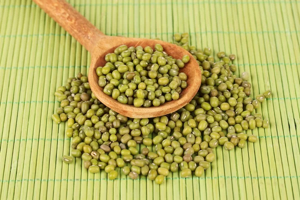 Mung beans over wooden spoon on color background — Stock Photo, Image