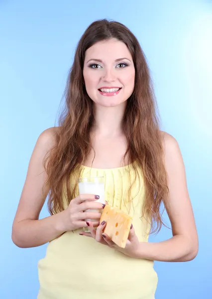 Szép nő, a tej és a sajt, a kék háttér — Stock Fotó