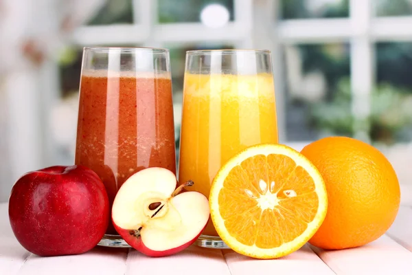 Zumos de frutas frescas sobre mesa de madera, sobre fondo de ventana — Foto de Stock