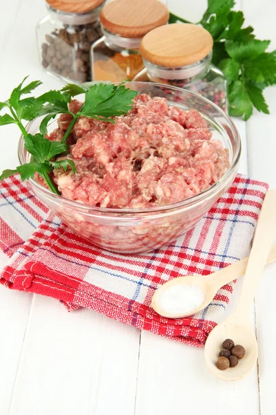 Bowl of raw ground meat with spices on wooden table — Stock Photo, Image