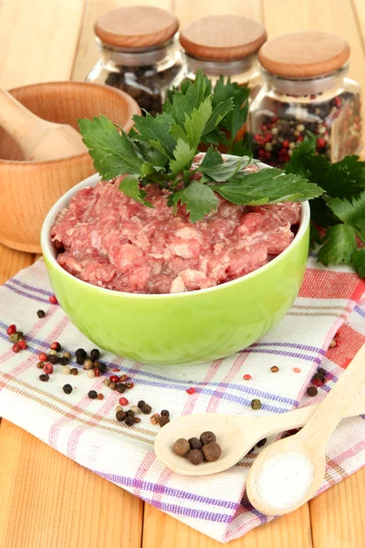 Cuenco de carne molida cruda con especias en mesa de madera —  Fotos de Stock