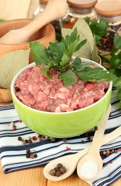 Schüssel mit rohem Hackfleisch mit Gewürzen auf Holztisch — Stockfoto