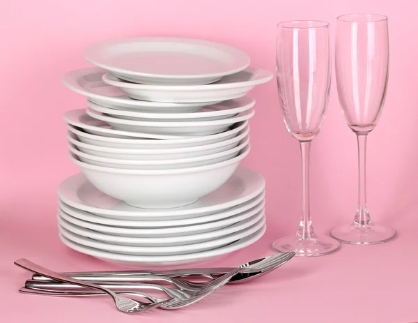 Clean white dishes on pink background — Stock Photo, Image