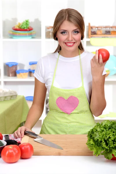 Uma jovem na cozinha enquanto cozinha — Fotografia de Stock