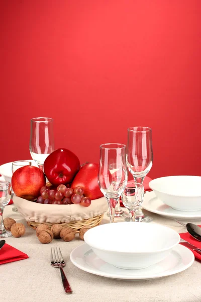 Table setting in red tones on color background — Stock Photo, Image