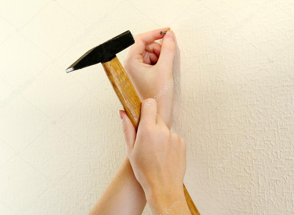 woman hands with nail and hammer