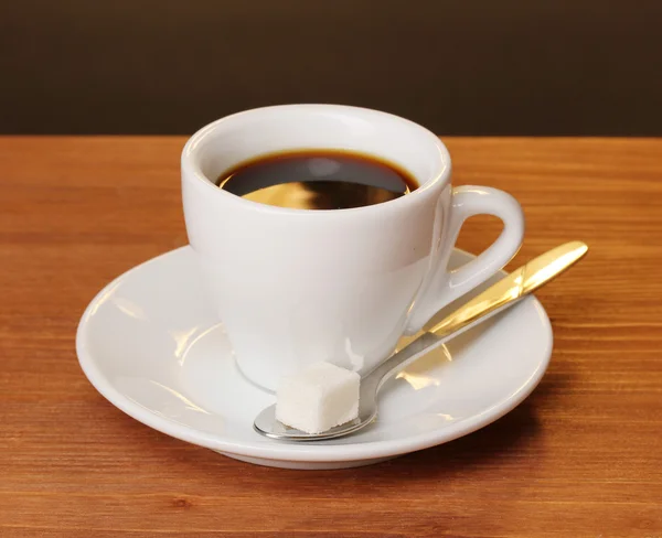 Coffee cup on wooden table on brown background — Stock Photo, Image