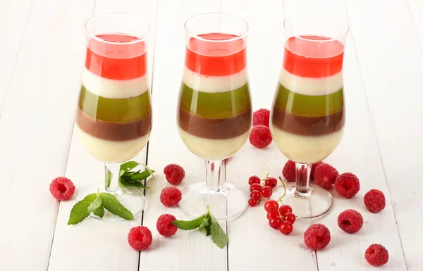 Gelatina di frutta in bicchieri, bacche e menta sul tavolo di legno — Foto Stock