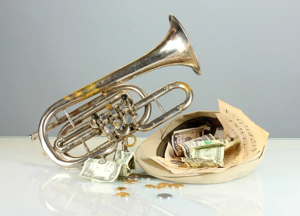 Musikinstrument med pengar på grå bakgrund — Stockfoto