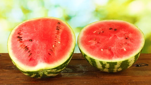 Hälften von saftigen Wassermelonen auf grünem Hintergrund Nahaufnahme — Stockfoto