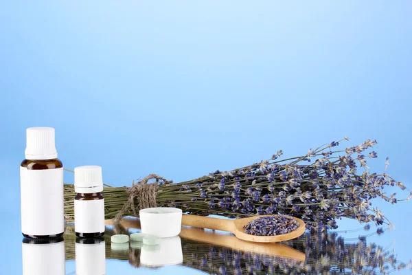 Bottiglie di medicinali ed erbe su sfondo blu. concetto di omeopatia — Foto Stock