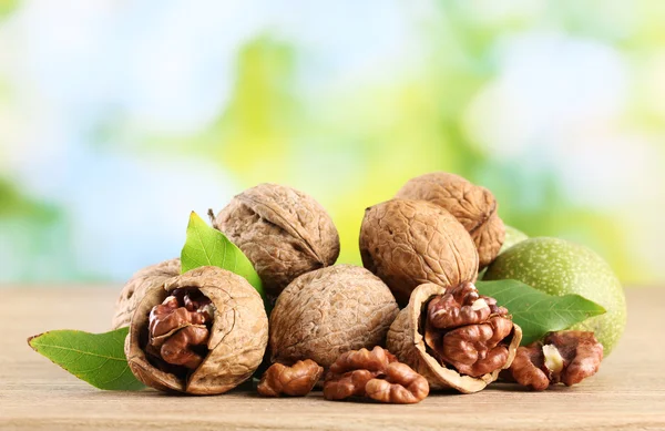 Walnuts with green leaves, on green background — Stock Photo, Image