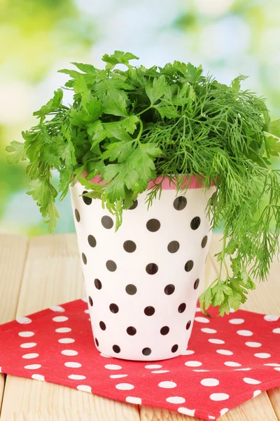 Vit kruka med persilja och dill på träbord på naturliga bakgrund — Stockfoto