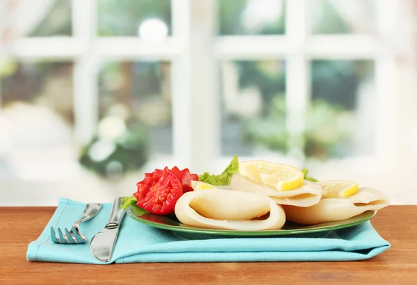 Calamares hervidos con verduras en el plato en la mesa de madera de cerca —  Fotos de Stock