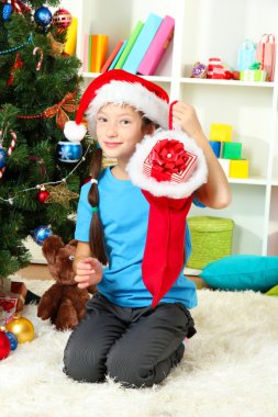 küçük bir kız tutmak Noel ağacının yanında oyuncak