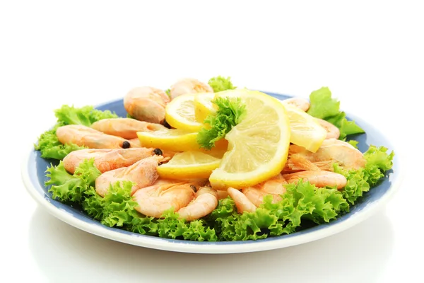 Варені креветки з лимоном і листям салату на тарілці, ізольовані на білому — стокове фото