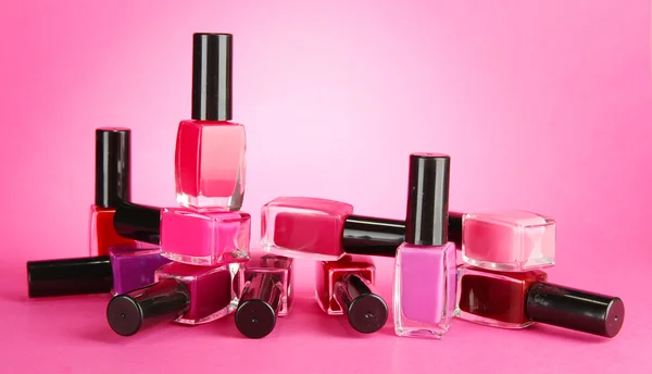 Group of bright nail polishes, on pink background — Stock Photo, Image