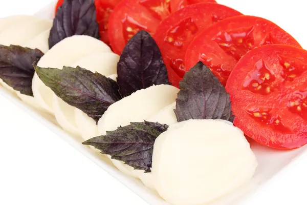Tasty mozzarella with tomatoes on plate close-up — Stock Photo, Image