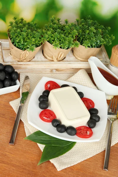 Feta-Käse auf Teller mit Gewürzen und Öl auf Holztisch auf natürlichem Hintergrund Nahaufnahme — Stockfoto