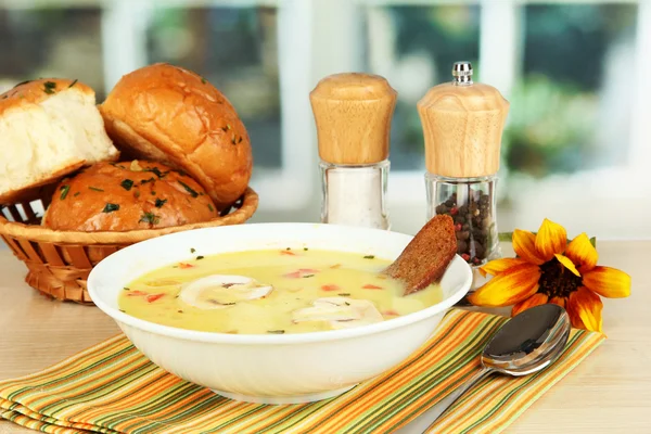 Soupe parfumée dans une assiette blanche sur la table sur fond de fenêtre close-up — Photo