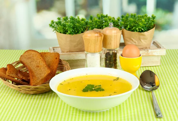 Soupe parfumée en assiette blanche sur nappe verte sur fond de fenêtre — Photo